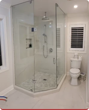 Corner glass shower with tiled surround and toilet
